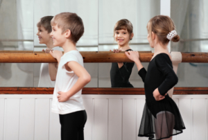 Funny,Children,Standing,At,Ballet,Barre