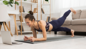 Fit,Woman,Doing,Yoga,Plank,And,Watching,Online,Tutorials,On