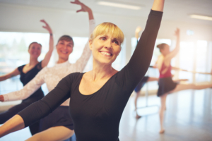 Cheerful,Smiling,Adult,Ballerina,Stretching,With,Hand,Up,Performing,A